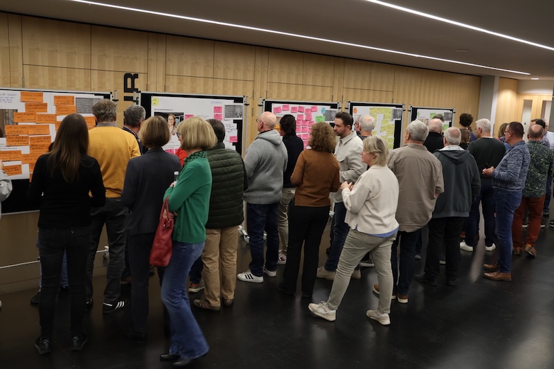 Menschen stehen eng vor Pinnwänden mit Workshop-Ergebnissen in Walldorf