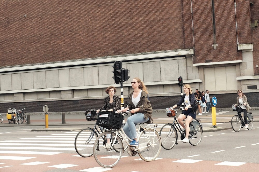 Jugendliche fahren mit dem Fahrrad über eine Kreuzung