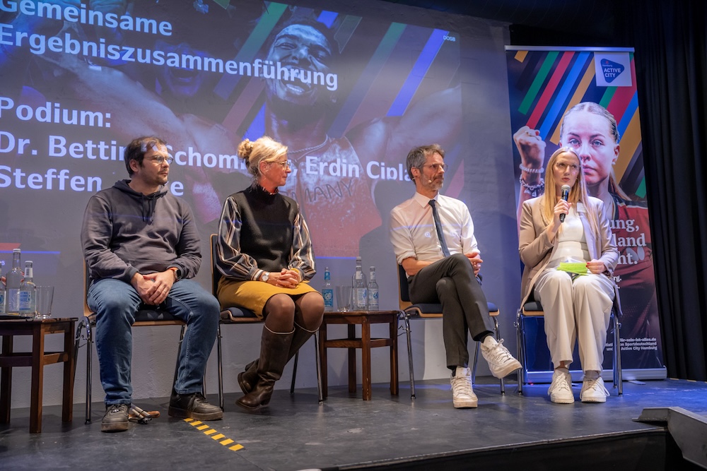 stadtmanufaktur-laura-ebeling-im-panel-credit-muhme-photography Laura Ebeling präsentiert auf einer Bühne die Ergebnisse eines Dialogformats zu Olympia in Hamburg